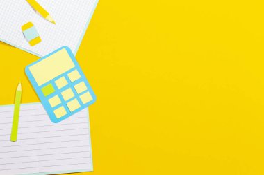 Okul eğitim Kağıt arka plan. Açık kitap, defter kalem hesap makinesi kağıt sarı arka plan üzerinde kesmek