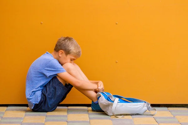 야외에서 다채로운 벽 근처에 앉아 슬픈 혼자 소년 — 스톡 사진