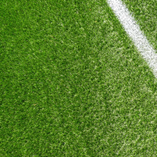 Зеленая синтетическая трава футбольное поле с белой полосой — стоковое фото
