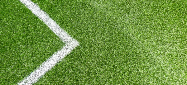 Зеленая синтетическая трава футбольное поле с белой угловой полосой — стоковое фото