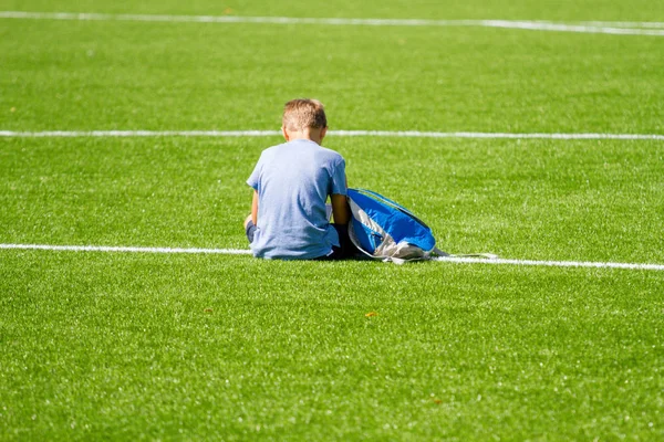Sad alone boy with backpack sitting stadium outdoors — Stock Photo, Image