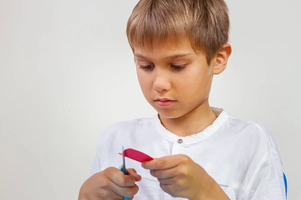 Bambino che taglia carta colorata con le forbici — Foto Stock