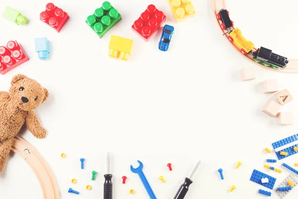 Crianças brinquedos fundo com blocos de construção e cubos, ferramentas de brinquedos, trem de madeira e ursinho de pelúcia — Fotografia de Stock