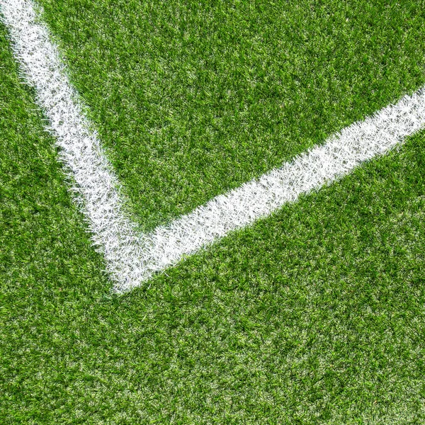 Zelená syntetická tráva fotbal sportovní hřiště s bílou rohovou pruh řádku — Stock fotografie