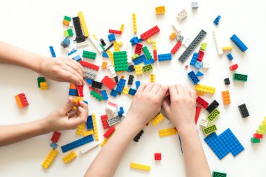 Vilnius, Litvanya - Nisan 2017. Çocukların elleri beyaz masada renkli lego bloklarıyla oynar..