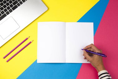 Kadın el not defterinde renkli arka plan üzerinde yazma