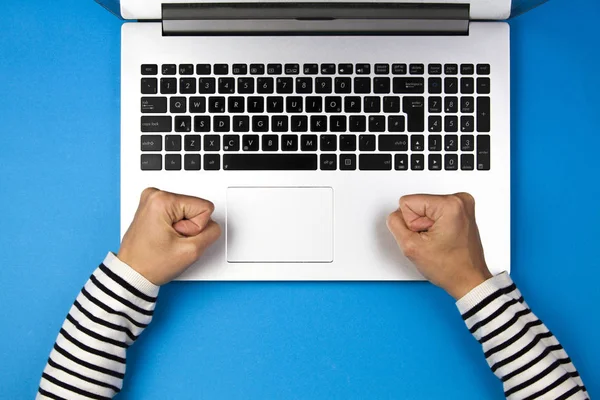 Knutna nävar hitt laptop tangentbord på blå bakgrund slog näven — Stockfoto