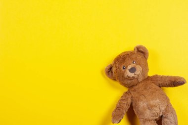 Teddy bear toy on yellow background. Top view clipart
