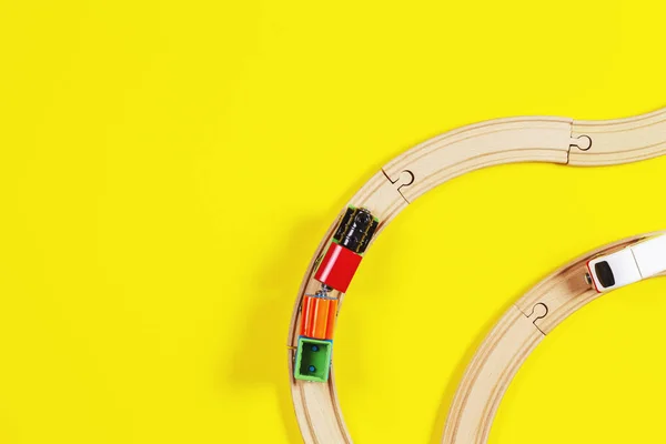 Trem de brinquedo e trilhos de madeira em fundo de cor amarela e azul — Fotografia de Stock