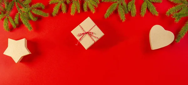 Christmas composition on red backgroud with fir tree branches and present gift boxes on red background. — Stock Photo, Image