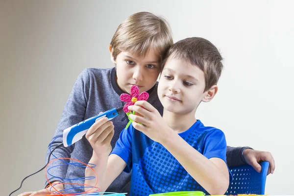 Два мальчика, создающие с помощью 3D-печатной ручки — стоковое фото