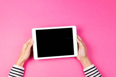 Tablet bilgisayarda pembe bir arka plan ile kadının el.