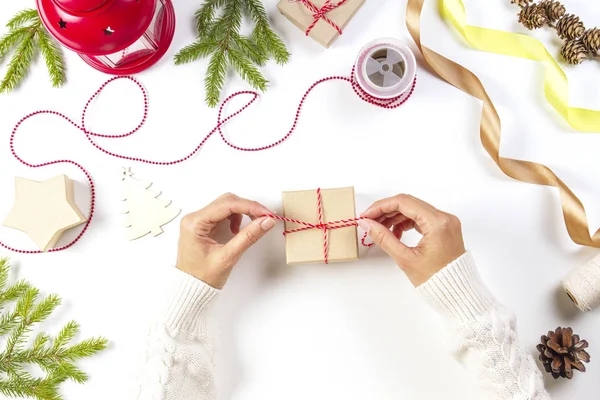 Karácsonyi ajándék csomagolás. Womans kezek csomagolás karácsonyi ajándékokat, a fehér asztal — Stock Fotó