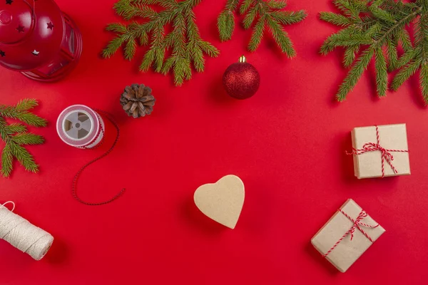 Christmas presentpapper. FIR tree grenar, kottar och nuvarande presentaskar på röd bakgrund — Stockfoto