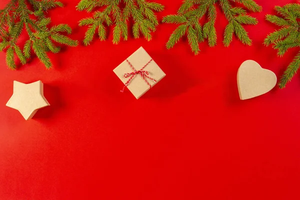 Composição de Natal. Ramos de árvore de abeto e caixas de presente no fundo vermelho — Fotografia de Stock