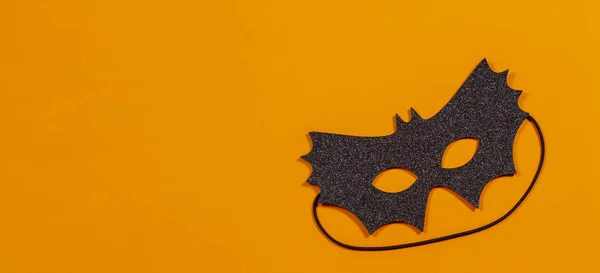 Czarna maska halloween na pomarańczowym tle — Zdjęcie stockowe