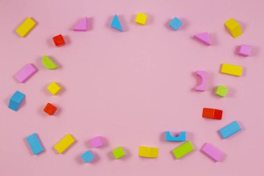 Pembe bir arka plan üzerinde renkli ahşap yapı taşları