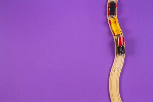 Trem de brinquedo e trilhos de madeira em fundo violeta roxo — Fotografia de Stock