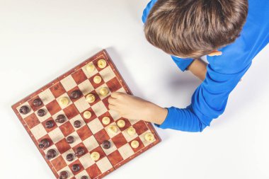 Satranç tahtası üzerinde satranç oyunu oynayan çocuk. Üstten görünüm