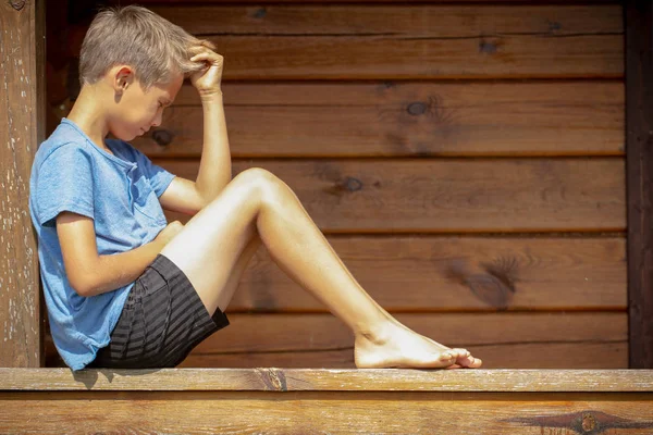 Triste chico solitario sentado al aire libre — Foto de Stock