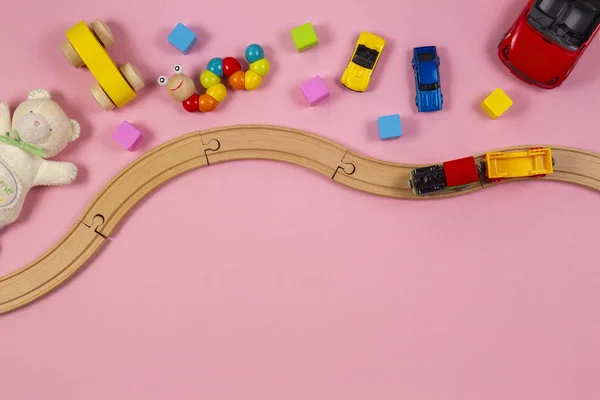 Baby barn leksaker ram med trä tåg, färgglada kuber, leksaksbil, nallebjörn, på rosa bakgrund. Ovanifrån — Stockfoto