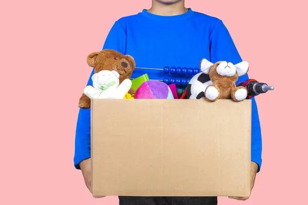 Donatie concept. Kid bedrijf doneren doos met kleding, boeken en speelgoed — Stockfoto