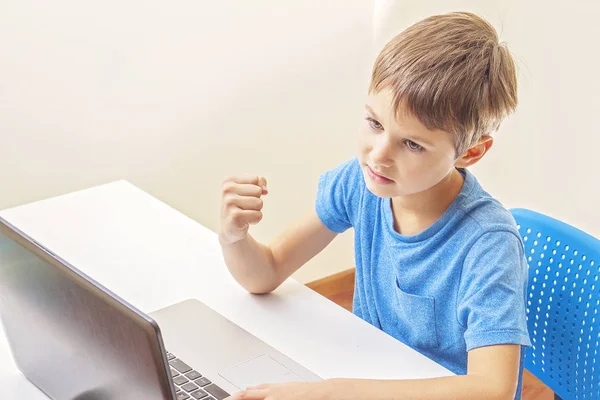 Bambino che gioca ai giochi per computer con il computer portatile a casa — Foto Stock