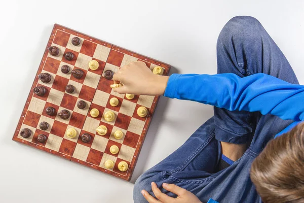 Kid playing chess game on chessboard. Top view — Stock Photo, Image