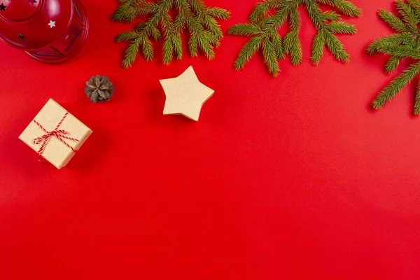 Composição de Natal. Ramos de abeto, cones de pinheiro e caixas de presente no fundo vermelho — Fotografia de Stock