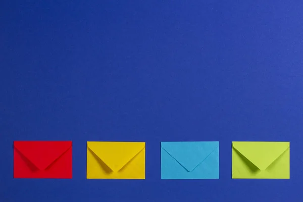 Kleurrijke enveloppen op blauwe achtergrond, bovenaanzicht — Stockfoto