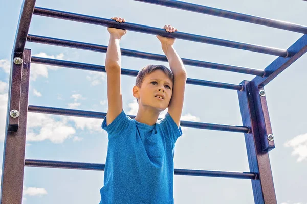 Treinamento infantil em uma estrutura de escalada no playground ao ar livre — Fotografia de Stock