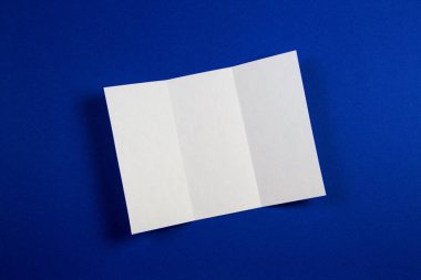 Boş beyaz üç katlı kitapçık broşür mavi zemin üzerine mockup