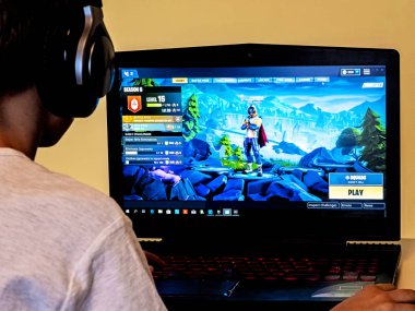Vilnius, Lithuania - November 12, 2018: Boy playing Fortnite. Fortnite is online video game developed by Epic Games clipart