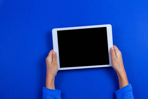 Tablet bilgisayarda mavi arka plan ile çocuk el — Stok fotoğraf