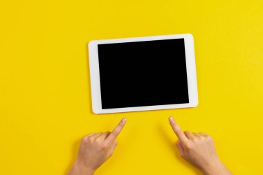Çocuk el parmak tablet bilgisayar sarı zemin üzerine işaret