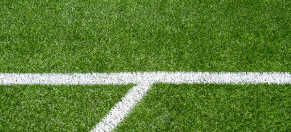 Green synthetic artificial grass soccer sports field with white corner stripe line