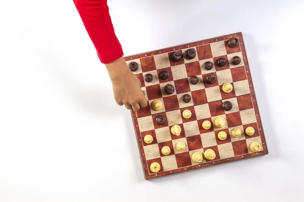 Kid hands over a chessboard playing chess game. Top view — Stock Photo, Image