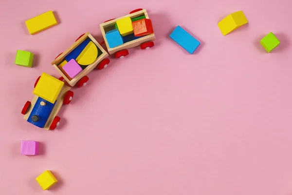 Σκελετός παιχνίδια υπόβαθρο. Ξύλινο παιχνίδι τρένο με πολύχρωμο μπλοκ για παστέλ ροζ φόντο — Φωτογραφία Αρχείου