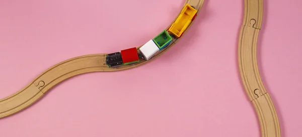 Trem de brinquedo e trilhos de madeira no fundo cor-de-rosa — Fotografia de Stock