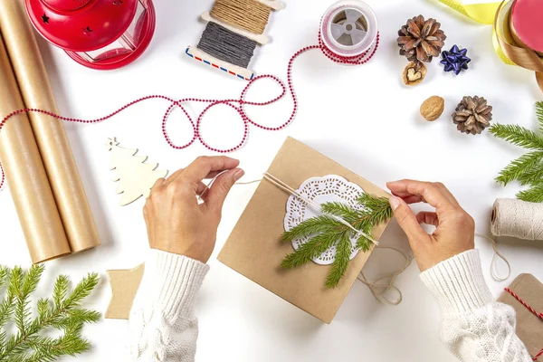 Kerst geschenkverpakking. Dames handen verpakking Kerstcadeaus op witte tafel — Stockfoto