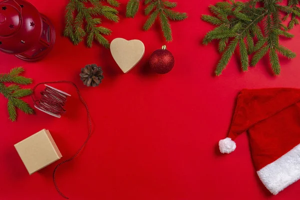 Christmas presentpapper. FIR tree grenar, kottar och nuvarande presentaskar och santa hatt på röd bakgrund — Stockfoto