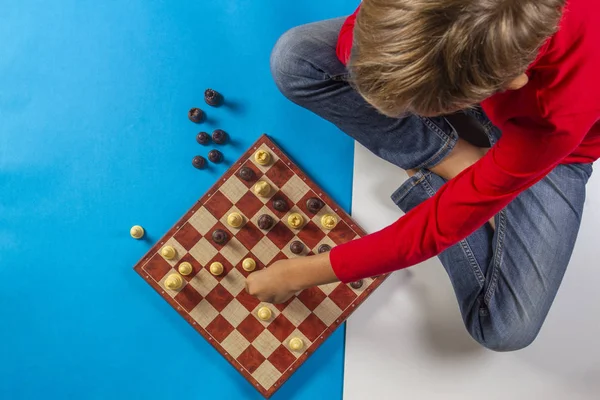 Kid sitting near chessboard and play chess game — Stock Photo, Image