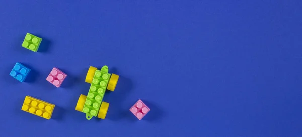 Colorful plastic toy car building blocks on blue background — Stock Photo, Image