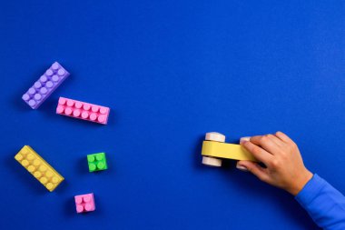 Ahşap oyuncak araba mavi arka plan ile oynayan çocuk eller