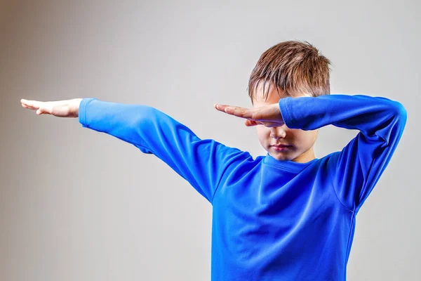Kid kastar dab på bakgrunden av en grå vägg — Stockfoto