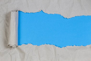Kahverengi paket kağıt kopya alanı ile mavi arka plan ortaya çıkarmak için yırtılmış