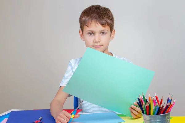 Kid cortando papel colorido com tesoura na mesa — Fotografia de Stock