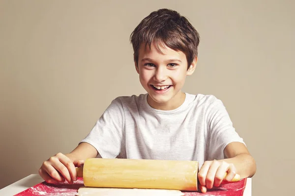 Kid rullar ut pizza degen med rullande pin på silikon degen rullande och bakning matta — Stockfoto