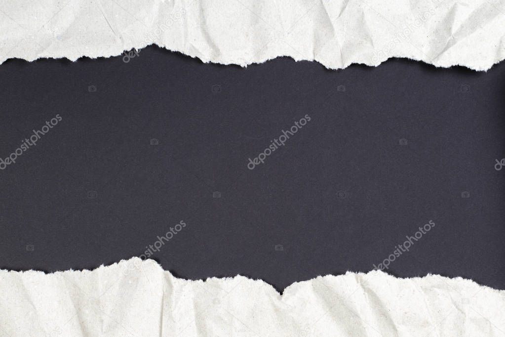 Crumpled package paper torn to reveal black background with copy space