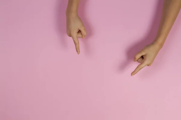 Las manos de los niños apuntando sobre fondo rosa pastel — Foto de Stock